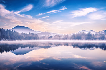 Hintersee lake in Germany, located in Ramsau parkland. Beautiful morning scenery of Alpine lake, misty picturesque landscape. Charming Alps in Background. European popular recreation site.