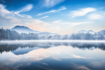 Lake Hintersee in Germany. Amazing morning landscape, foggy state of nature, autumnal scenery at background of Alps.
