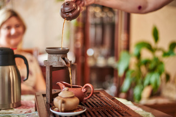 hand with grinder and cup of coffee on wooden table