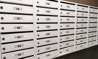 a lot of white mailboxes in modern apartment building
