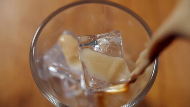 A top angle of chocolate shake being poured into the glass. 