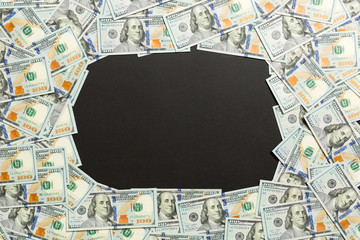 Fototapeta na wymiar Frame of one hundred dollar bills with empty space for your design. Top view of business concept on black background with copy space