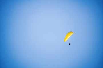 Paragliders floating through a blue sky over Camps Bay, Cape Town.