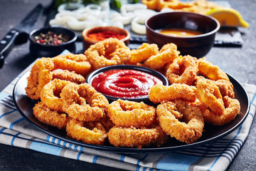 crispy calamari rings on a black plate