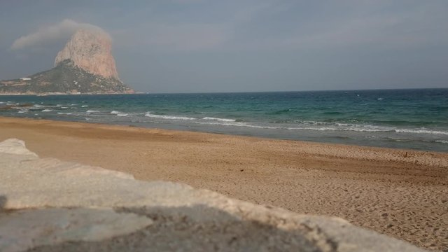 Beautiful view of Penyal d'Ifac on a sunny bright day at Calp beach with mediterranean sea waves