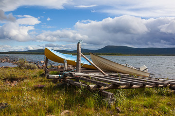 Colorful boats on the bank of the picturesque lake in Swedish Lapland, Norrbotten County