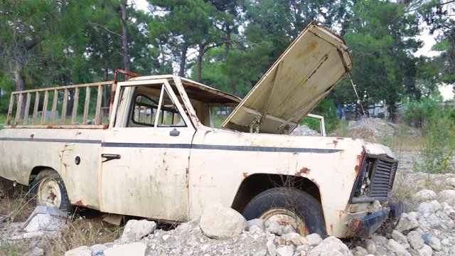 Extremely old and worn car standing in forest. Real time full hd video footage.