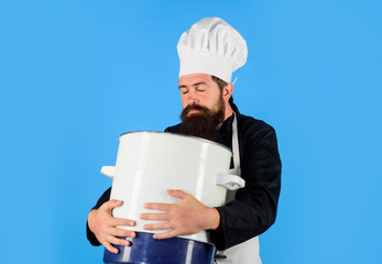 Male chef cook holds big pot. Cooking, culinary. Food, profession and people concept. Cook man in apron holds saucepan in kitchen. Cooking pot, saucepan, casserole. Cookware, dinnerware, kitchenware.