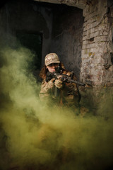 Fighter in full ammunition with guns in smoke shoot in an abandoned building