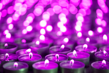 Purple pink candle light. Christmas or Diwali celebration tealight candlelight. Christmas vigil lights - obrazy, fototapety, plakaty