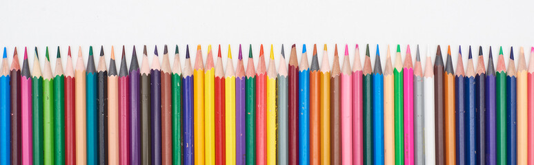 Panoramic shot of straight line of color pencils isolated on white