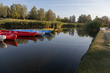 jetty in pond of city of zaragoza in spain, with canoes and boats