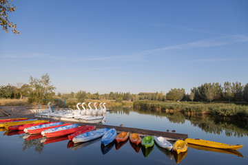 jetty in pond of city of zaragoza in spain, with canoes and boats
