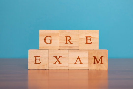 Concept Of GRE Exam In Wooden Block Letters On Table.