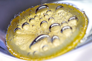 a slice of lemon with bubbles.  Fresh lemon slice in water with bubbles