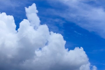 White fluffy clouds floating on bright blue sky in sunny day..