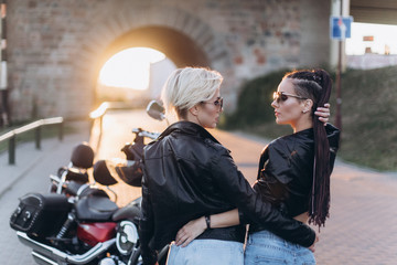 Sexy gorgeous young women outdoors with motorcycle on road. Friendship, beauty, sexy lady, transportation concept