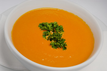 Bowl of soup, parsley and croutonson on a gray background