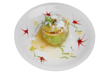 Baked apple with vanilla sauce on a plate on a white isolated background