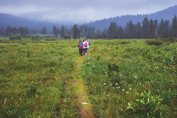 Fototapeta na wymiar Group of hikers walking in the field in the Ergaki National park in Russia