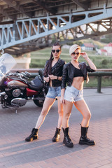 Sexy gorgeous young women outdoors with motorcycle on road. Friendship, beauty, sexy lady, transportation concept