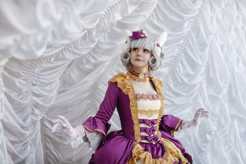 Girl in barocco baroque rococo old vintage dress and wig stand near white curtains, cosplay costume of 15 16 17 18 19 century