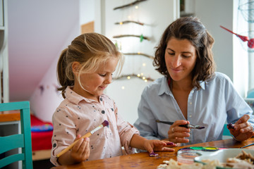 Mother and daughter painting Christmass ornaments