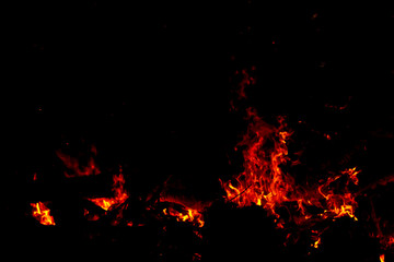 Fototapeta na wymiar The sparkle of the flames in the dark background.