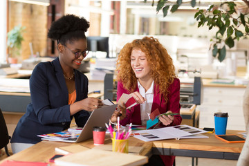 Interior designers laughing while working together in the office