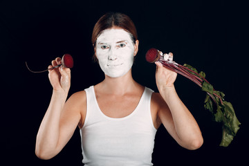 Young woman applying make-up, paints face with sugar beet and makeup. How not to do make up concept.