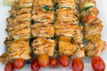 Assorted meat from chicken and pork and various vegetables on barbecue grill 