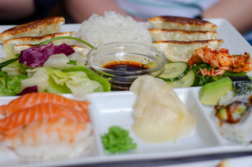 japanese fried dumplings and rice, fresh latuck salad, sushi rolls and sauce for lunch