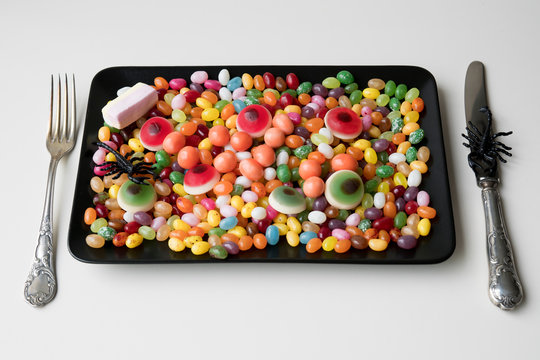 sweet meal whit mixed candy, jelly beans, eyes, on black plate