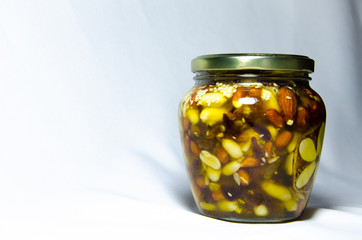 Nuts and assorted nuts in a jar of honey and brown bread with cereals