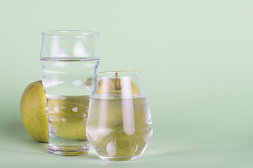 Glasses and apple on green background
