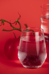 Tomatoes on branches with glasses of water
