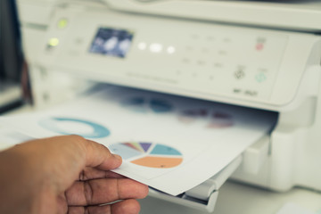 Business printer / printing documents in office concept:Businessman press document graph for report...