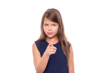 Little girl points her finger at you isolated on white background.