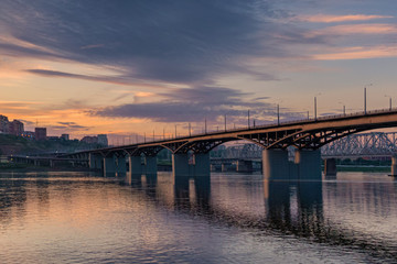 Bridge over the Yenisei river, evening sunset. Krasnoyarsk, Russia. panorama of the evening city