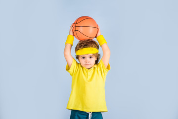 Small boy in sport uniform playing basketball. Little basketball player in sportswear trows ball....