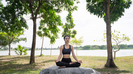 Young beautiful woman practices yoga and meditates outdoor at the mountain. Female doing yoga and meditate to relax and release stress.