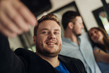 Man taking selfie with friends indoors