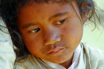 Poverty, portrait of a poor little African girl lost in deep thoughts