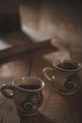 two antique cups of decorated coffee