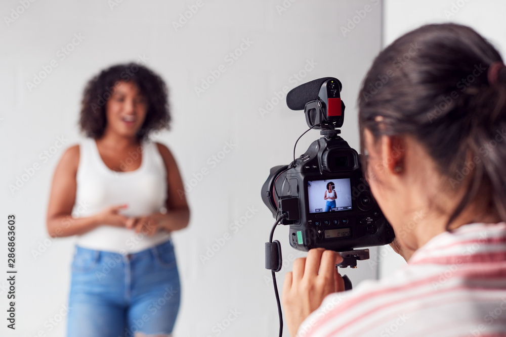 Wall mural female videographer recording woman recording podcast in studio