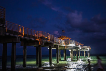 View of Orange Beach Alabama pier at night with lights illuminating it