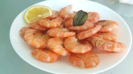 Kitchen and food, cooked shrimp, shrimp in a plate. Boiled shrimp with lemon. roasted prawns on white plate, top view.