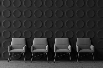 Row of armchairs in dark gray office lounge