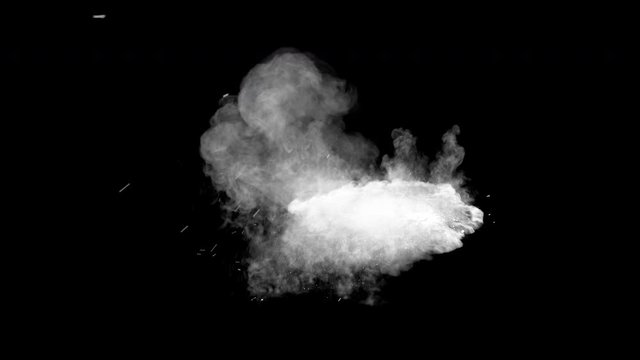 Bullet hits blue powder causing dusty burst and scattering of pieces. The dust settles on the ground. Separated on pure black background, contains alpha channel.