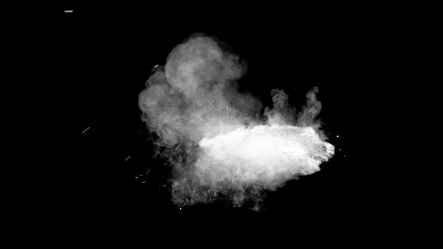 Bullet hits red powder causing dusty burst and scattering of pieces. The dust settles on the ground. Separated on pure black background, contains alpha channel.